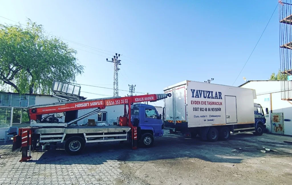Yavuzlar evden eve taşımacılık kamyonu ve kırmızı kiralık asansör aracı.